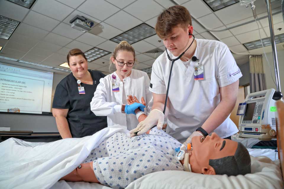 nursing students practicing on a mannequin